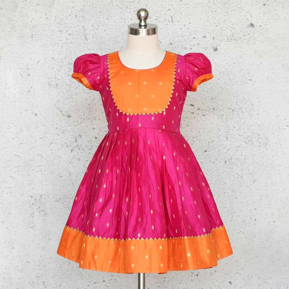 Pink and orange dress on a mannequin against a gray background