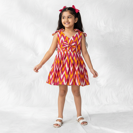girl wearing pink ikat cotton frock with bow