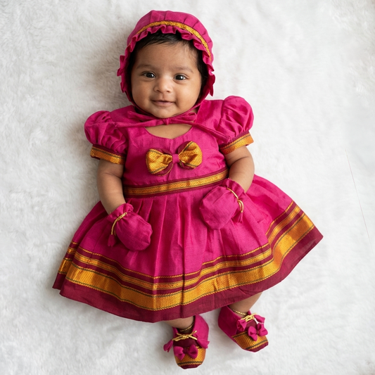 Baby girl wearing pink Paithani newborn set for naming ceremony with cap mittens and shoes