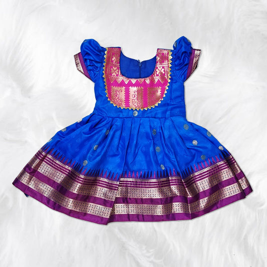 Toddler girl dressed in colorful Indian traditional dress with ethnic embroidery.
